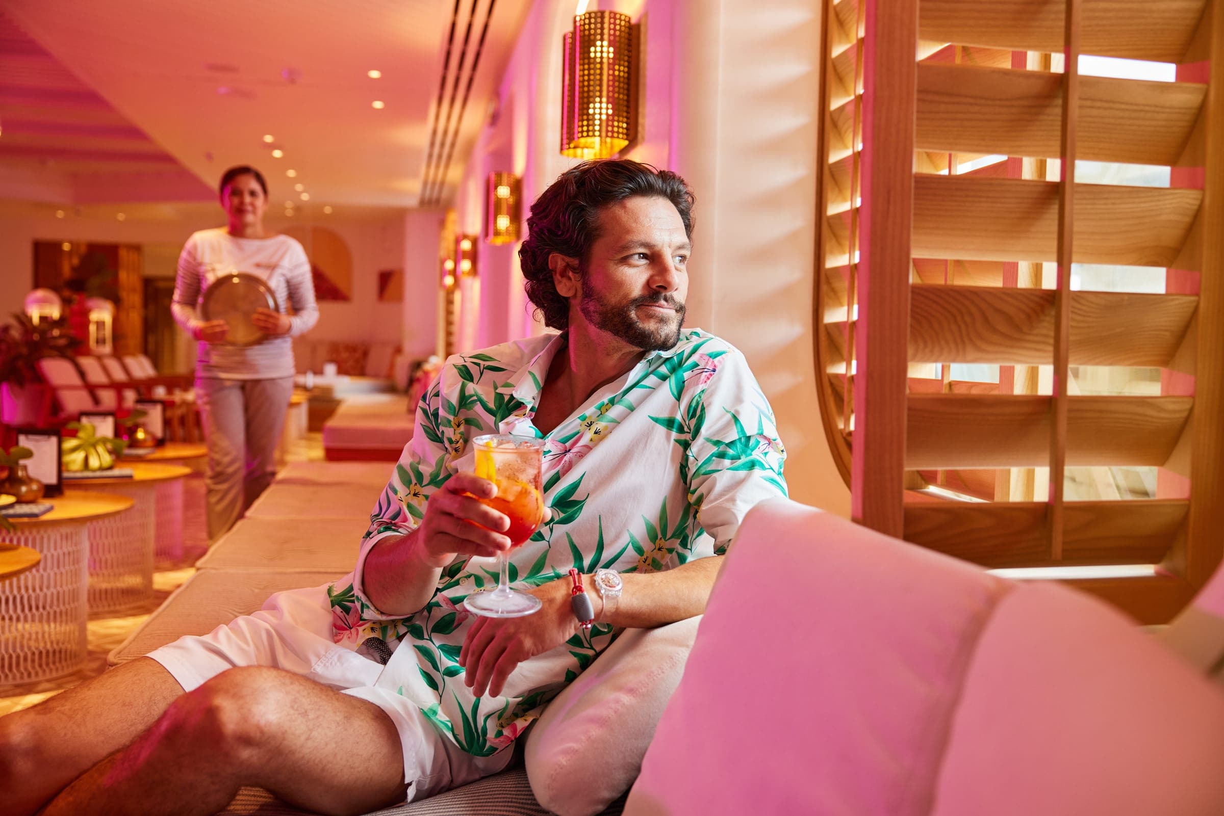 Man relaxing with a cocktail at The Dock House on Virgin Voyages